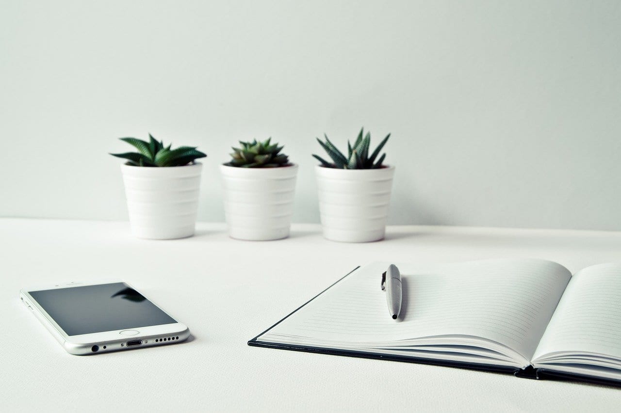 Desk with notepad, phone and plants